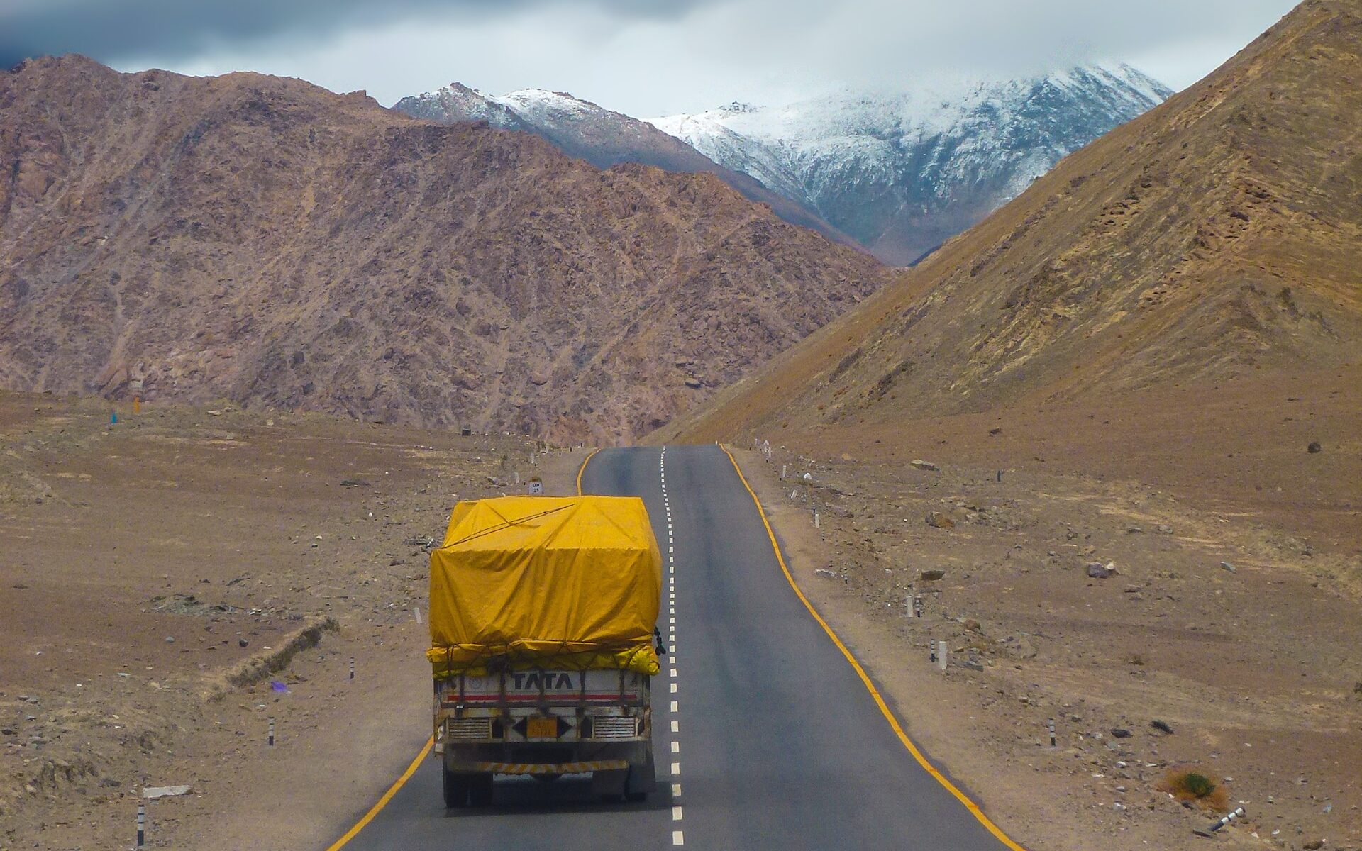 Truck In The Road With Alongside Mountains