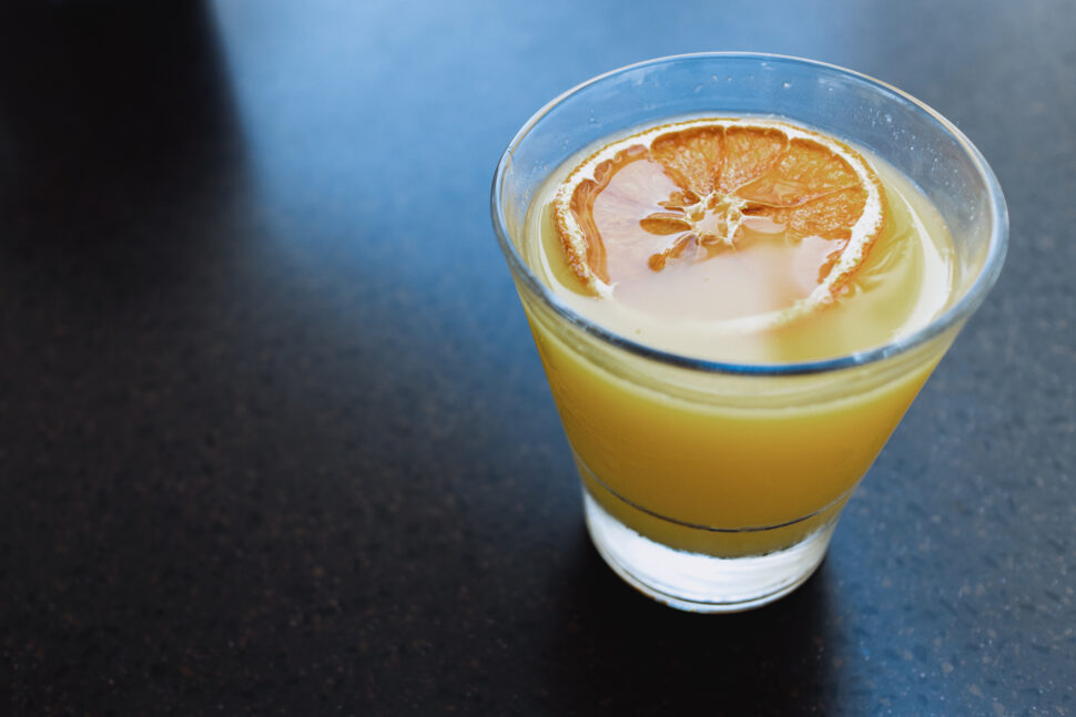 alcoholic beverage with citrus fruit floating