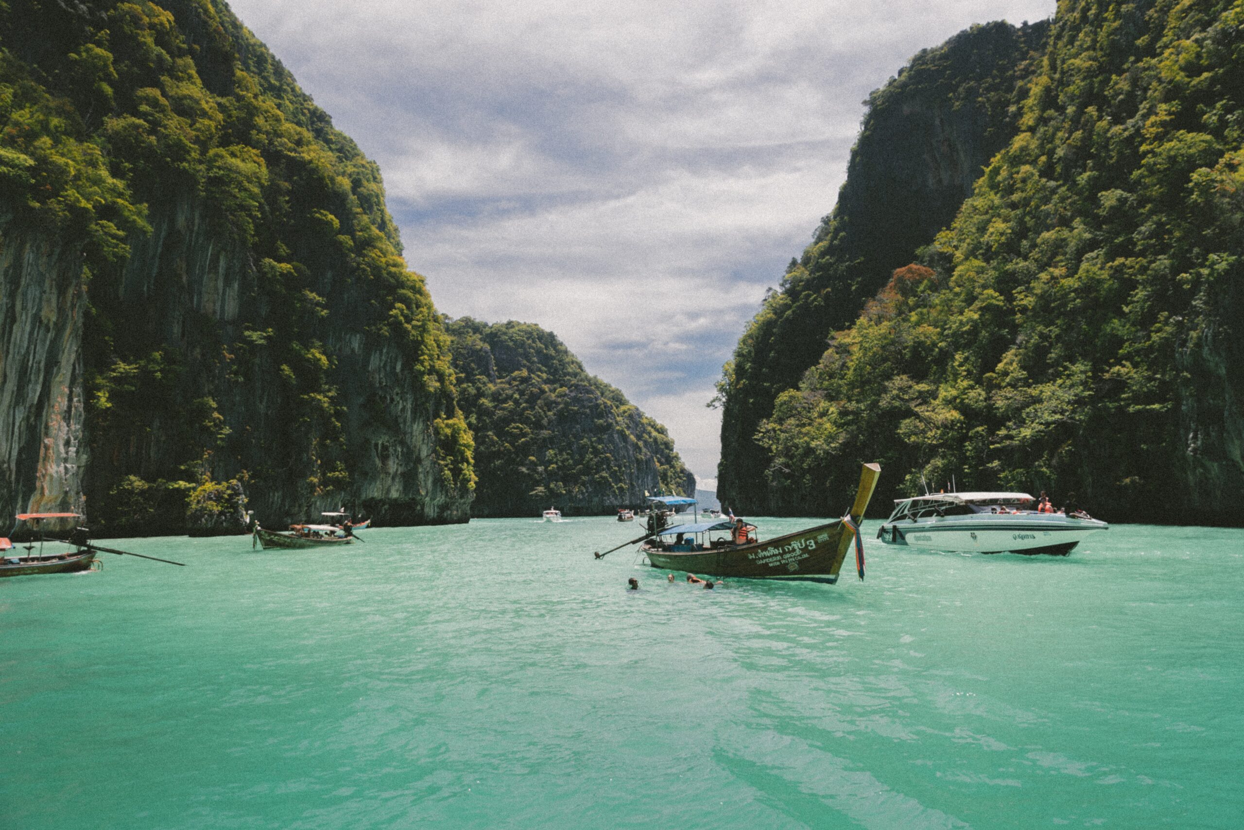 Thailand is a wonderful destination that is safe for travelers. Check out how tourists can travel safely and securely. 
Pictured: the turquoise waters of a series of islands with boats lingering 