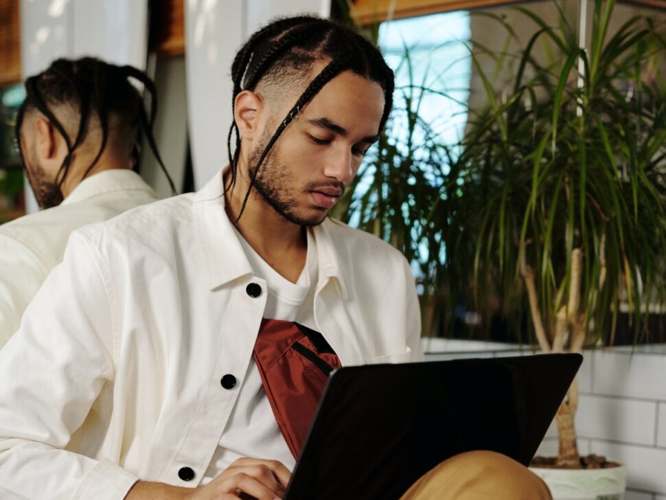 Man with braids on his laptop