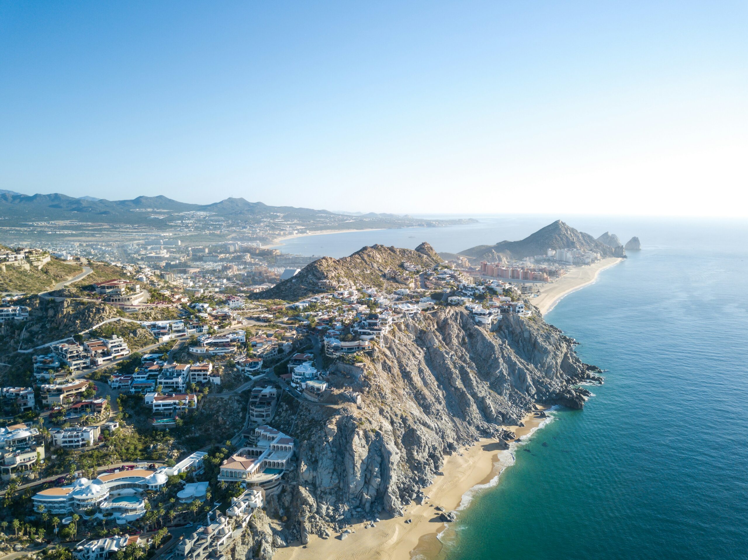 Learn more about Cabo and its safety level for tourists. 
pictured: an aerial view of Cabo and the coast 