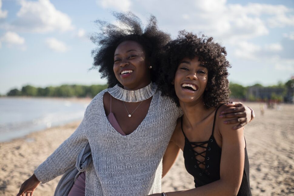 black women walking and laughing on beach
