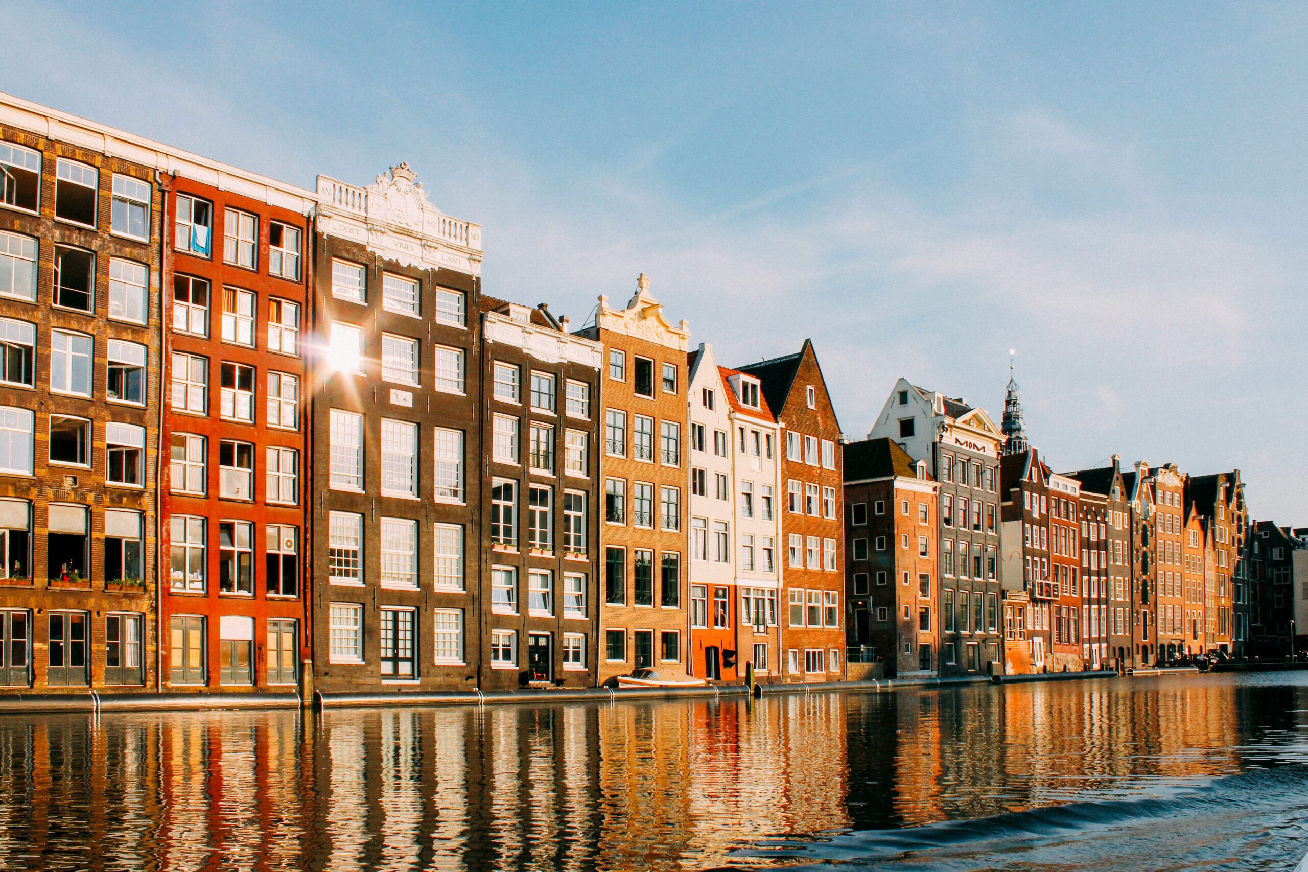 Amsterdam is one of the top cities in Europe for travelers. 
Pictured: a canal and historic buildings in Amsterdam on a bright sunny day 