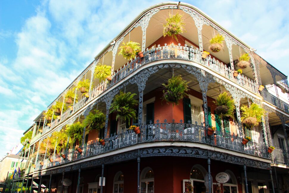 street view photo of French Quarter building with potted plants on balcony in New Orleans