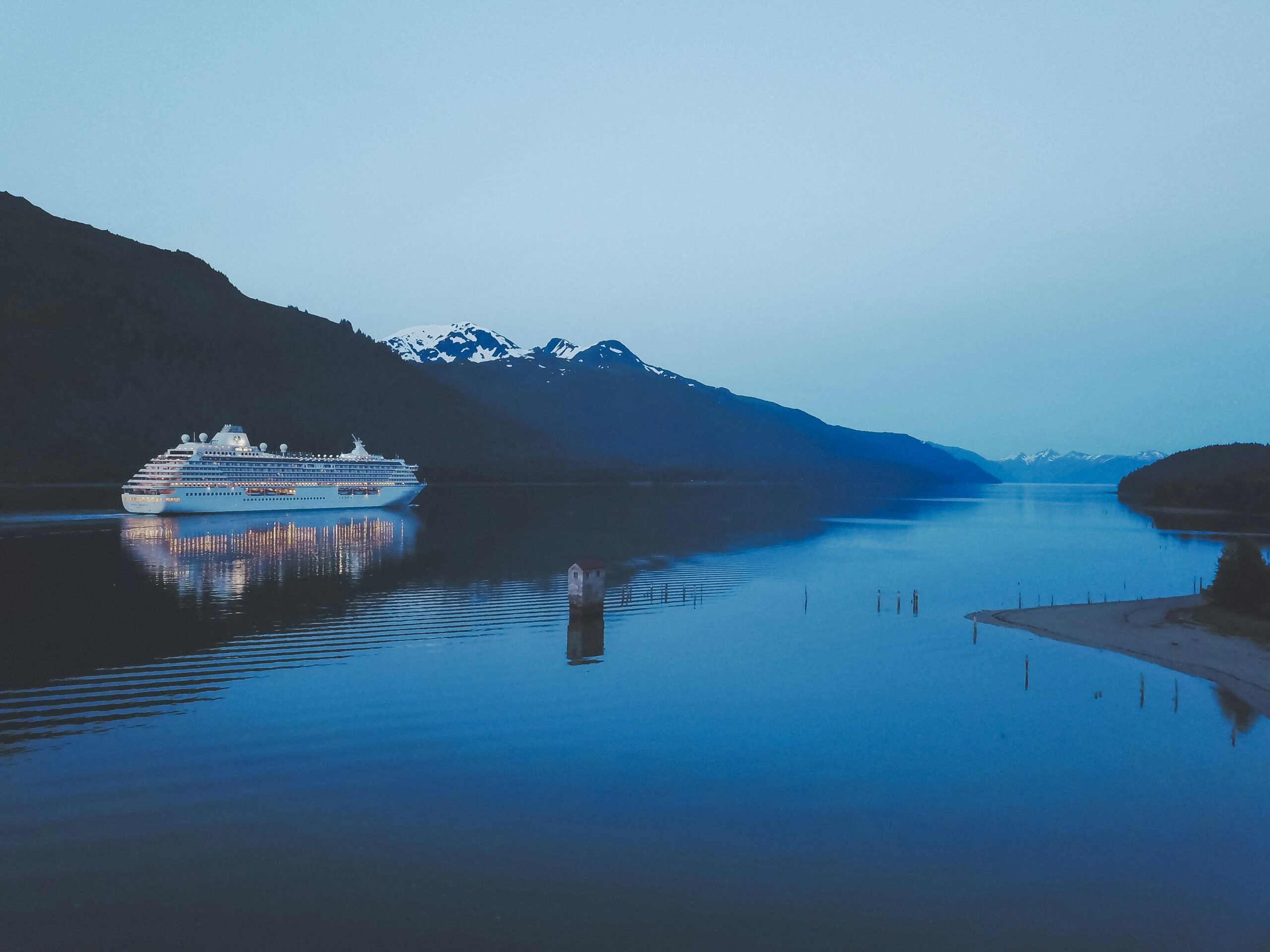 These ten excursions in Alaska are the best options for cruisers.
pictured: a cruise in the waters of Alaska with snowy mountains in the background