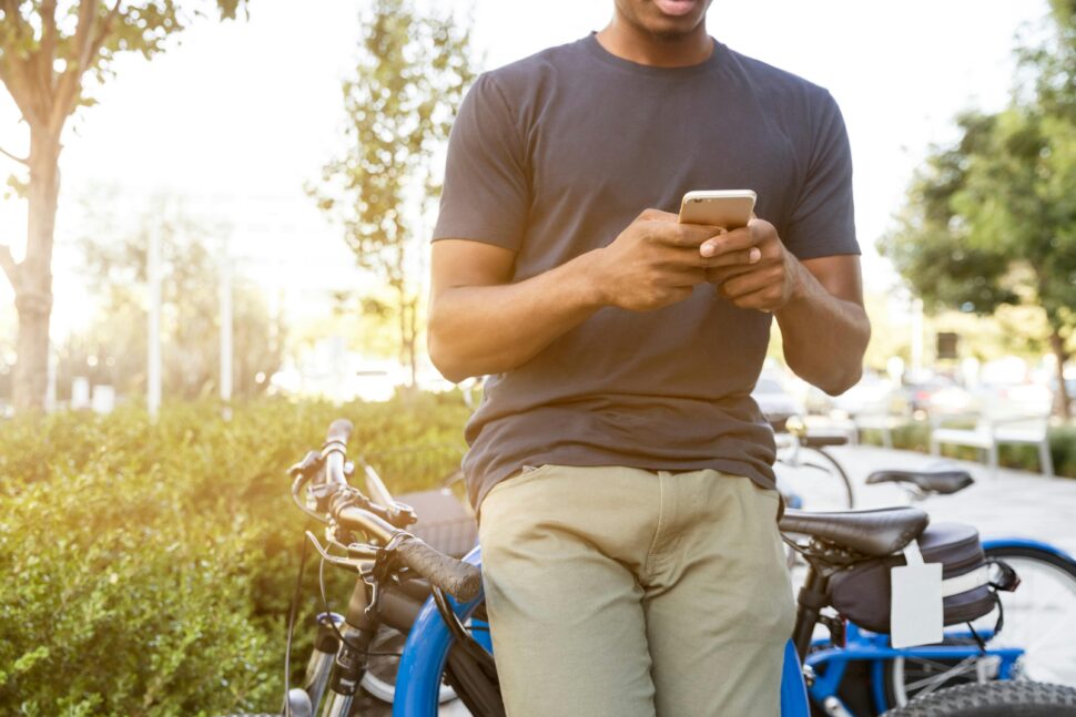 man standing by bikes using phone 