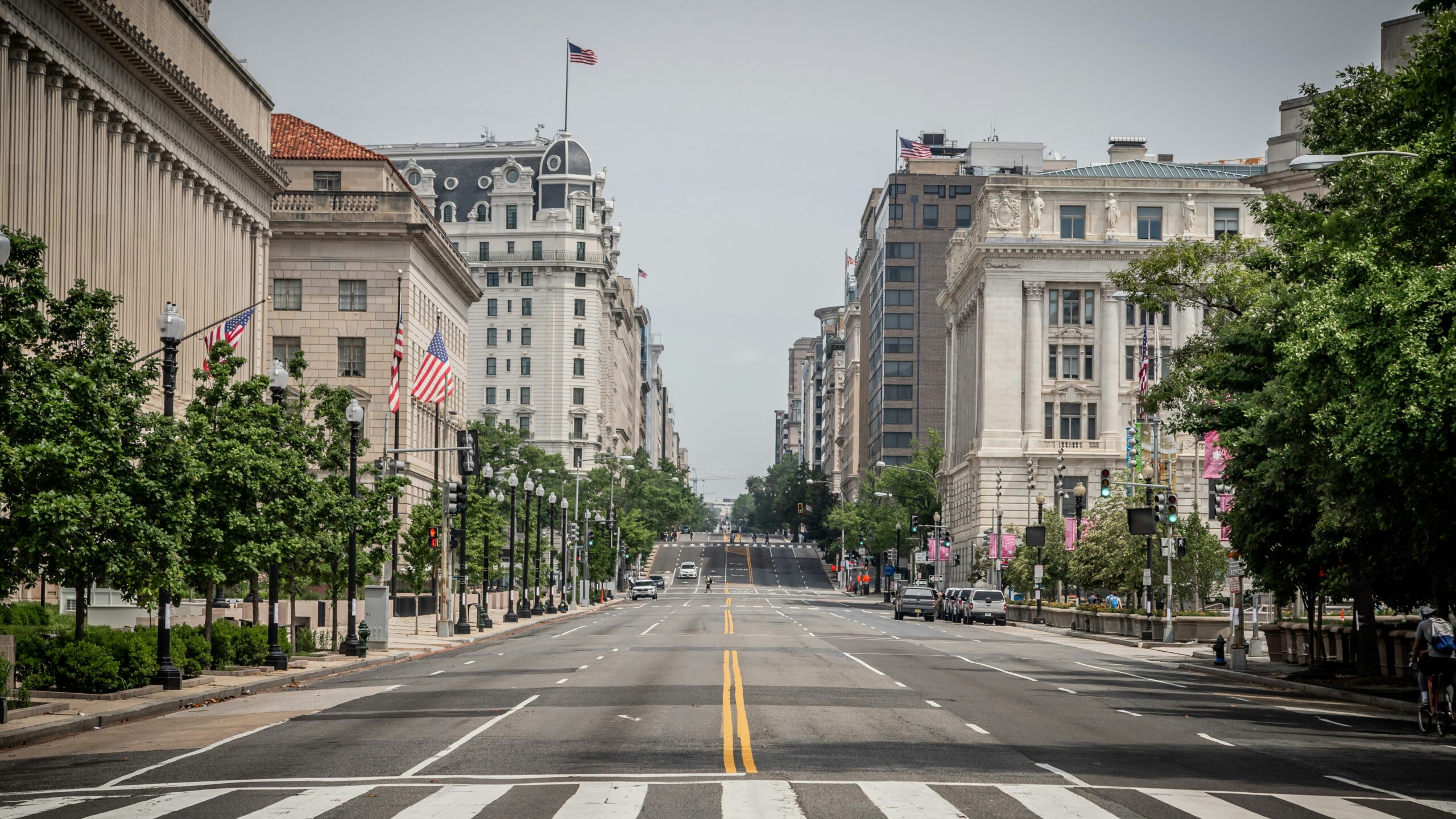 Lean more about the safety level of Washington D.C. and what things travelers should worry about. 
pictured: the streets of Washington D.C. with American flags and greenery around