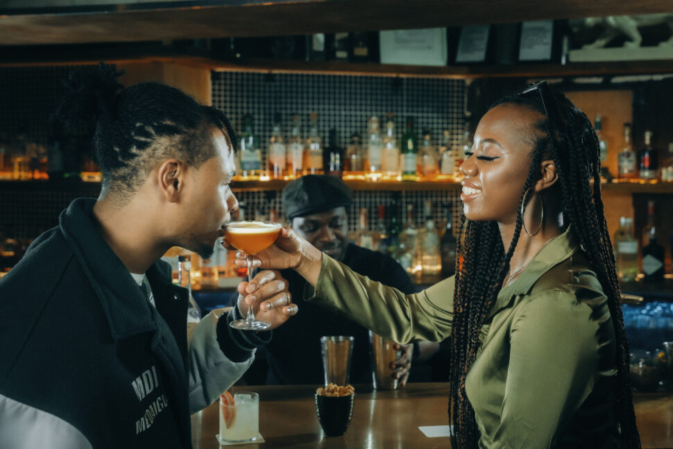 man and woman having drinks at a bar