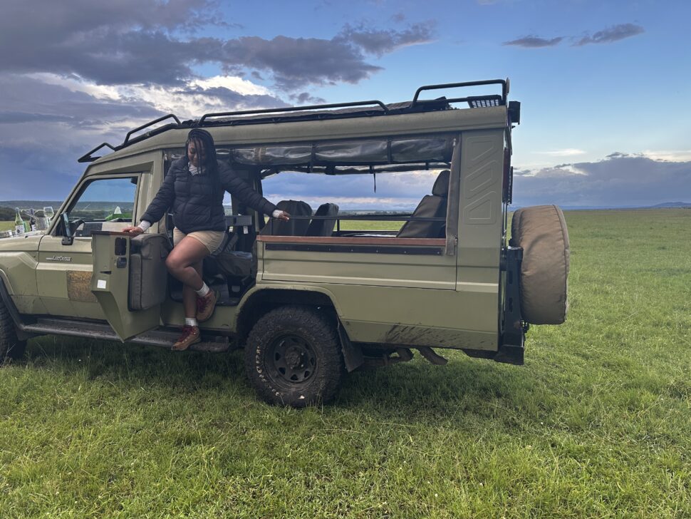 woman posing on safari truck at Maasai Mara National Reserve Safari in Kenya