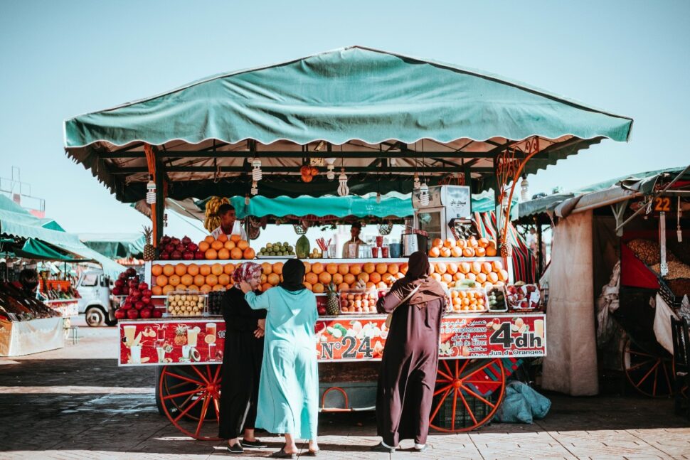 people standing by fruit stand in Marrakech, Morocco