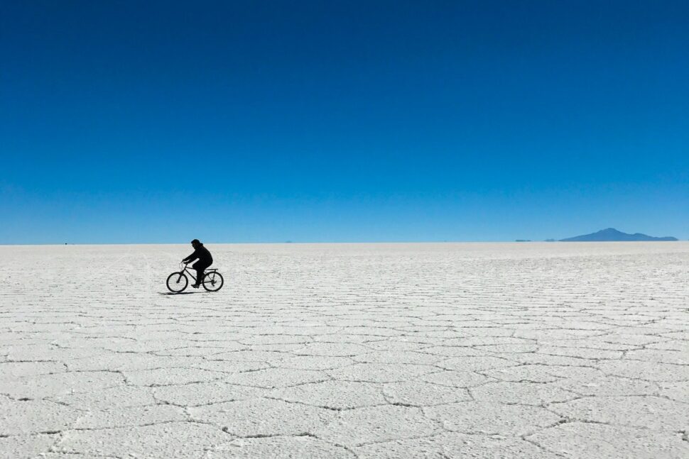 person riding bicycle across salt flat