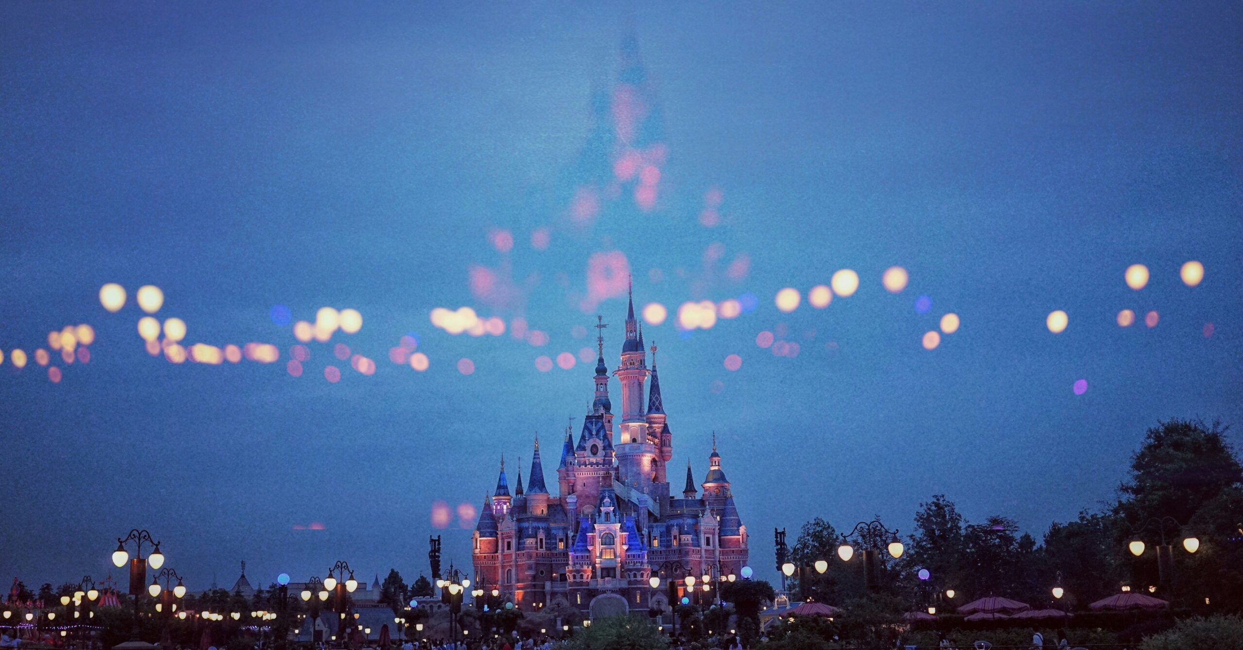 Check out how lying on the Disney DAS application can lead to a lifetime ban. Pictured: a Disney park with city lights in the background