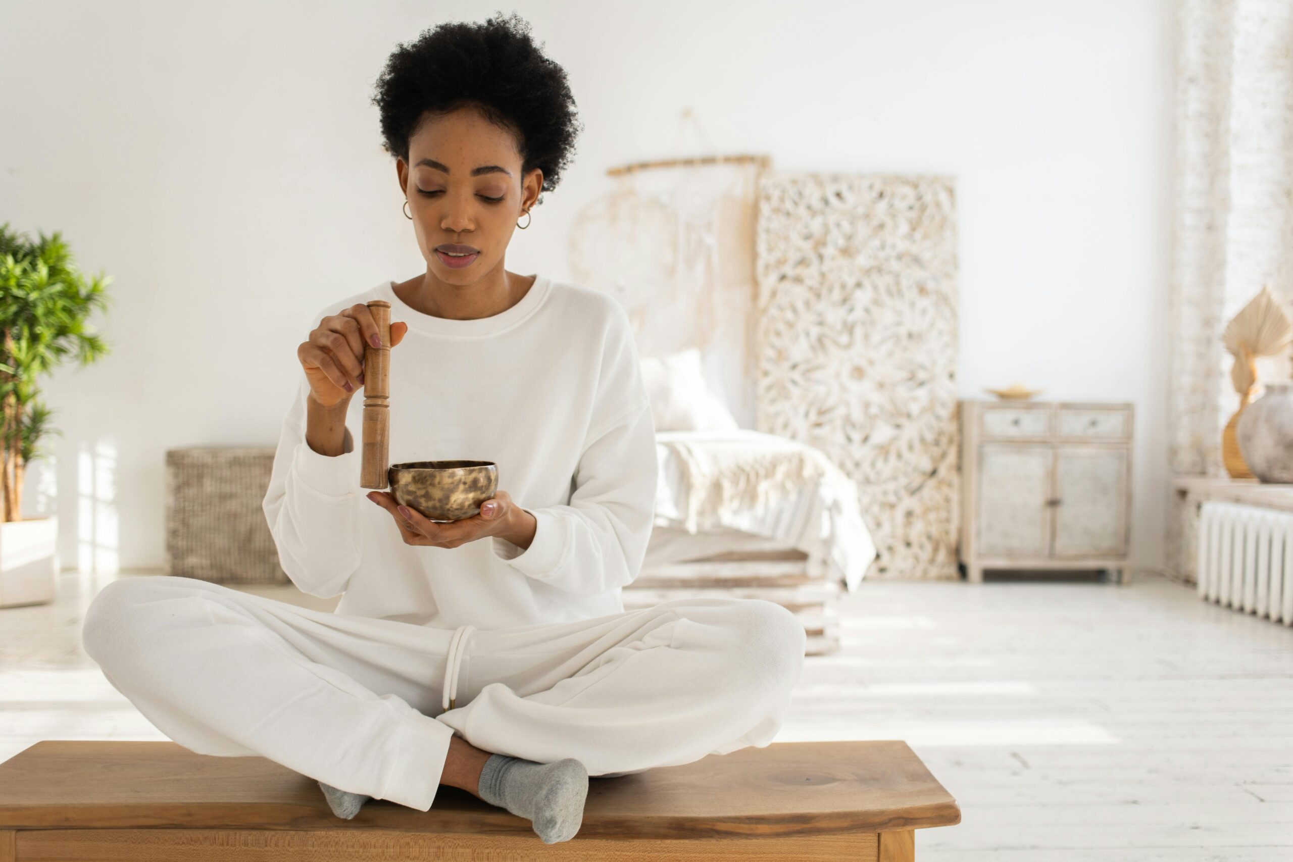 Check out some of the top retreats for a solo spring trip. 
Pictured: a Black woman using sound bowls for wellness 