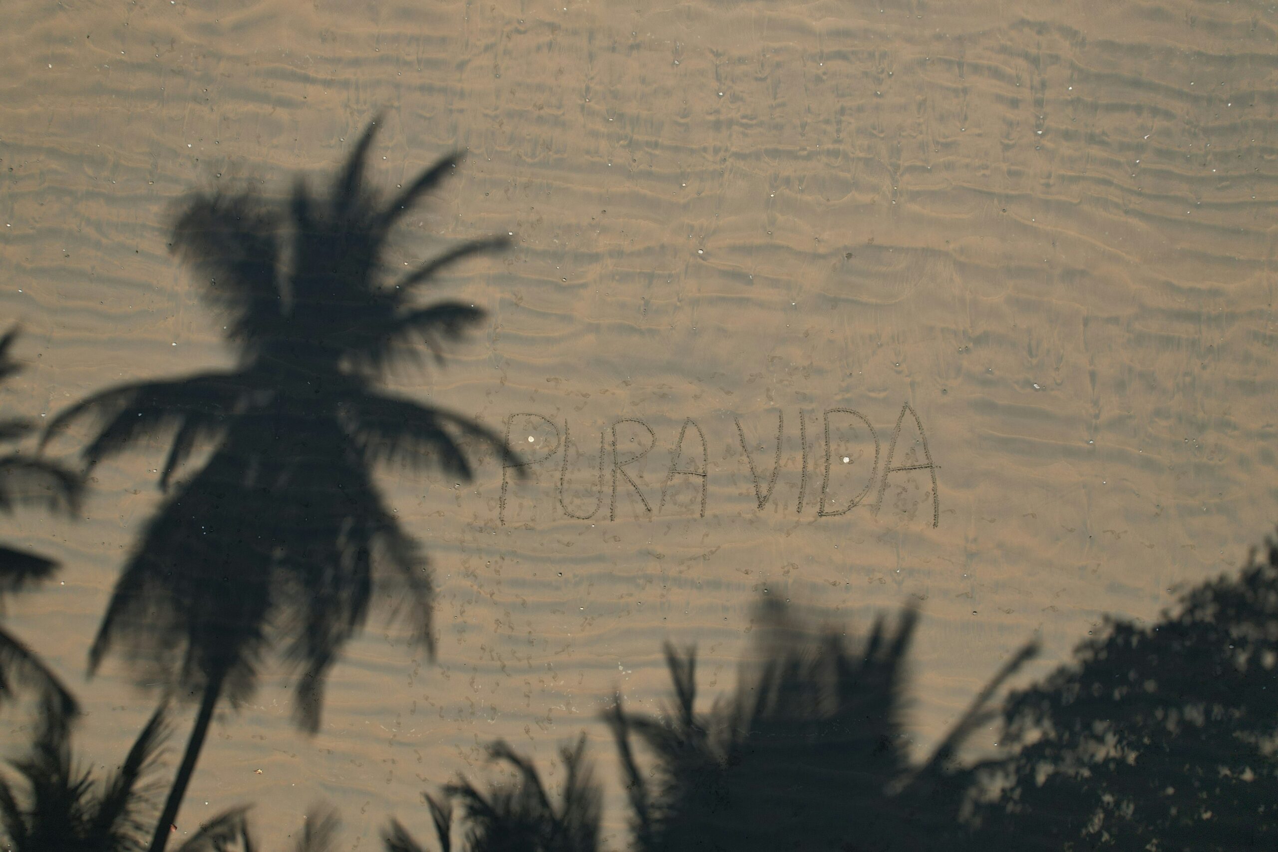 the phrase pura vida drawn in the sand in Costa Rica