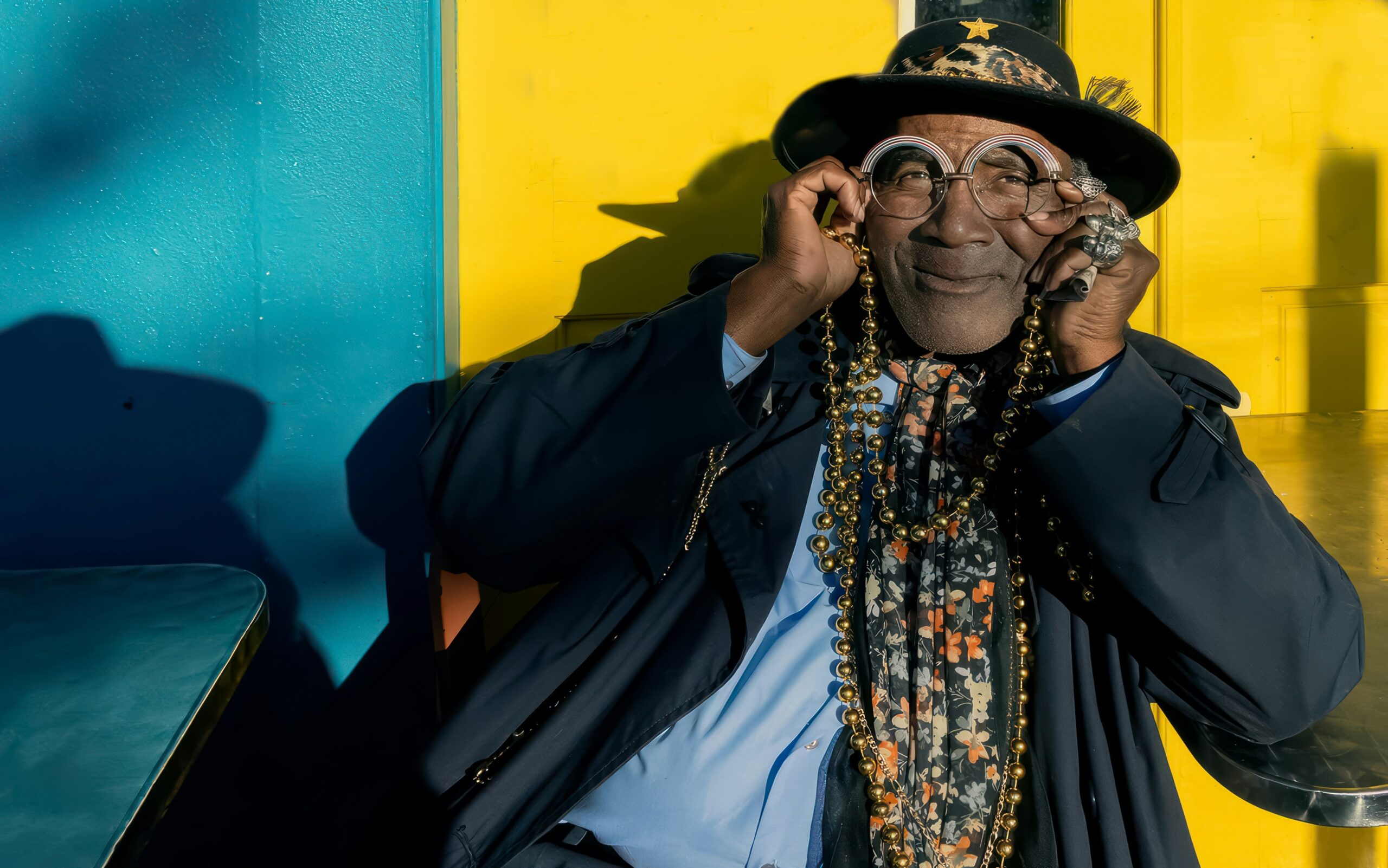 Mardi Gras is why one of the best times to visit New Orleans is March. 
pictured: an older Black man flaunting Mardi Gras souvenirs