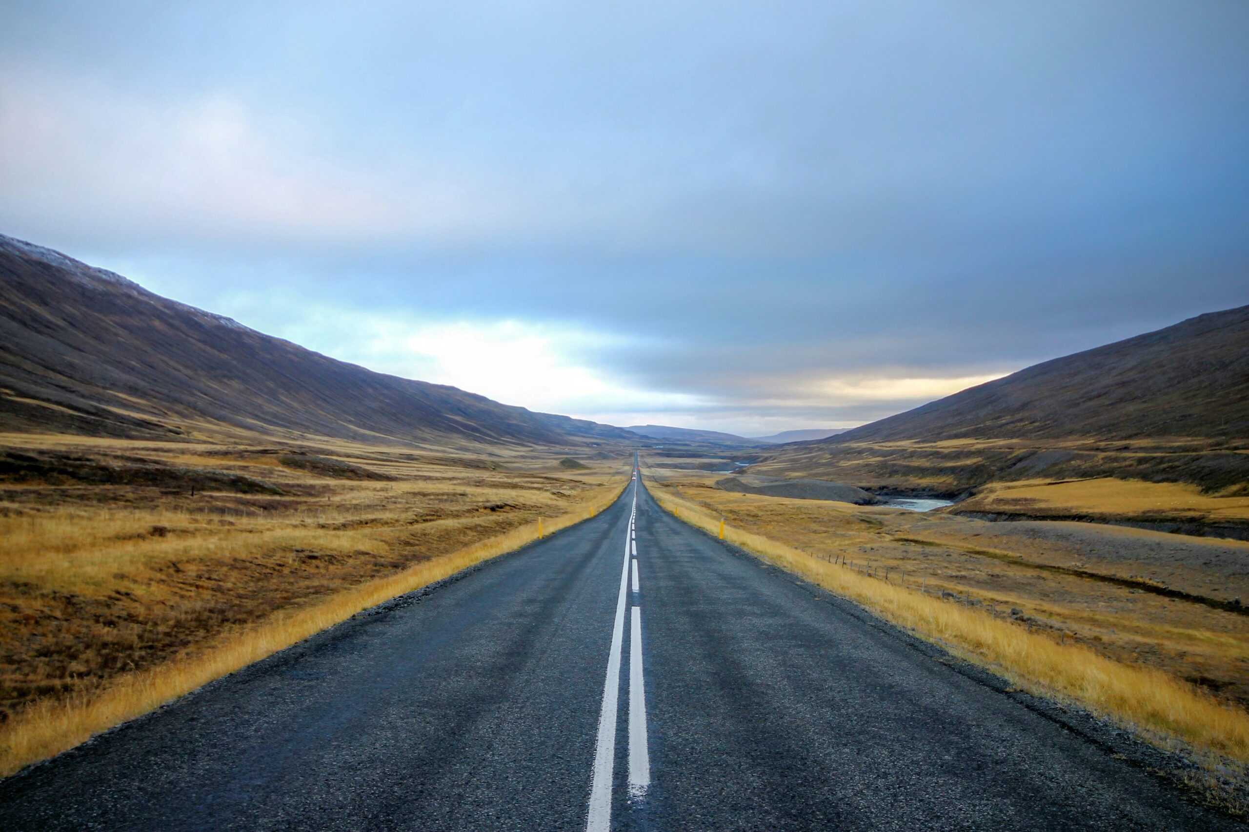 an open road and vast mountains in Iceland