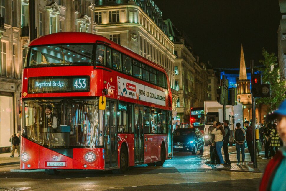 double decker red bus on London street at night